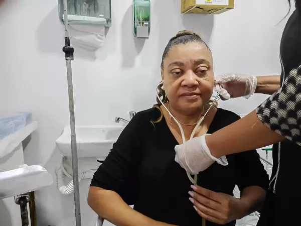 Ozonioterapia Auricular: Benefícios, Como Funciona e Indicações 1 Profissional da saúde preparando paciente para aplicação de ozonioterapia auricular.