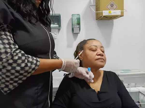 Ozonioterapia Facial: Rejuvenescimento, Benefícios e Como Funciona no Rosto 7 Profissional da saúde preparando paciente para sessão de ozonioterapia facial.